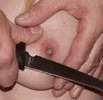 Picture of a Knife being held against a breast.